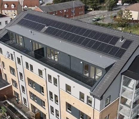 5 story building with solar panels on the roof.